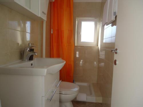 een badkamer met een toilet, een wastafel en een raam bij Apartment Prime Dubrovnik in Dubrovnik