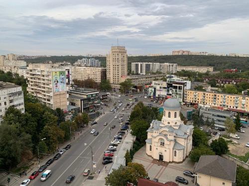 a city with a building and a street with cars at Apartment OneClickRenrt Oasis in Chişinău