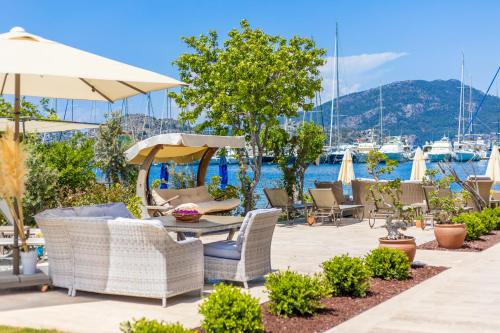 a patio with chairs and a table with an umbrella at Base Selimiye in Marmaris