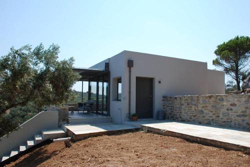 a white house with a stone wall and a patio at house λ in Skiathos