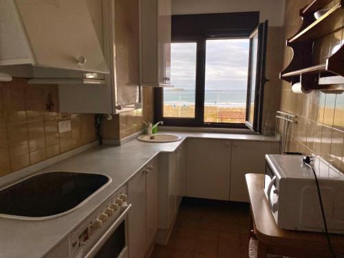 a kitchen with a sink and a window at Vistas al Mar in Somo