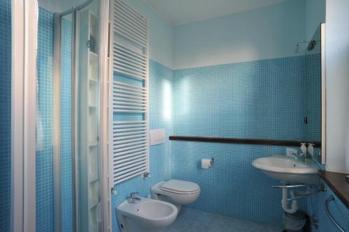 La salle de bains est pourvue de carrelage bleu, de toilettes et d'un lavabo. dans l'établissement Villa Augusta Sleeps 14 Exclusive Pool, à San Venanzo