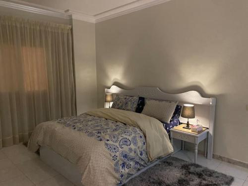 - une chambre avec un lit et une table avec une lampe dans l'établissement Nile View Apartment in Zamalek Stays, au Caire