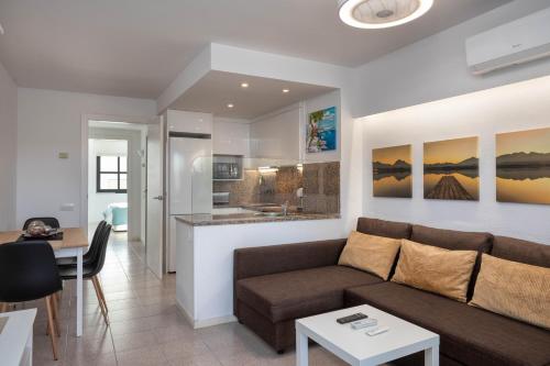 een woonkamer en een keuken met een bank en een tafel bij Hauzify I Apartament Port Mar in Platja  d'Aro