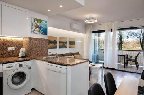 cocina y sala de estar con lavadora y secadora. en Hauzify I Apartament Port Mar, en Platja d'Aro