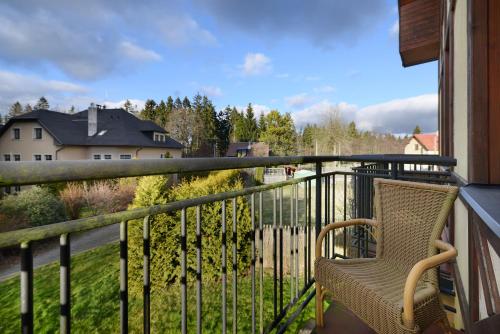 a balcony with a chair and a view of a house at Hotel Morris Relax & Wellness in Mariánské Lázně