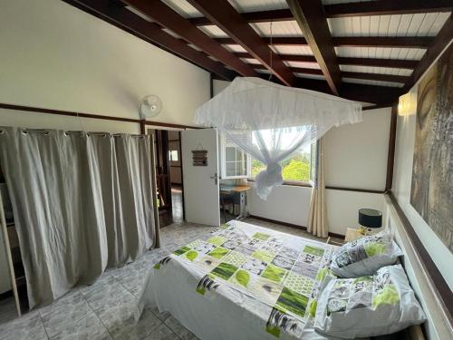 a bedroom with a large bed in a room with a window at B&B Plage Des Raisiniers in La Trinit&eacute;