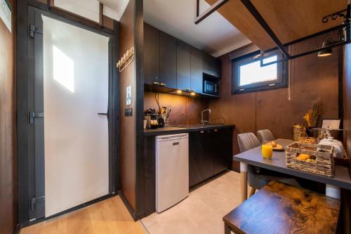 une cuisine avec une porte blanche, une table et un comptoir dans l'établissement Escale Royale Frejus, à Fréjus