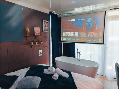 a bathroom with a tv and a tub and a sink at Escale Royale Frejus in Fréjus