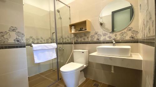 ein Badezimmer mit einem WC, einem Waschbecken und einem Spiegel in der Unterkunft ZEN garden in Xuyên Mộc