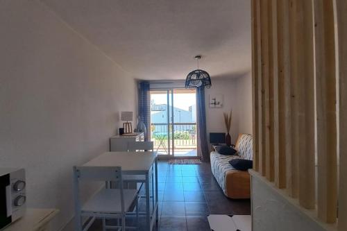 a living room with a table and a couch at Studio Port du Cap d'Agde in Cap d'Agde
