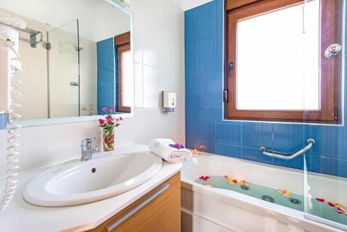 a bathroom with a sink and a bath tub at Villa Kiotari Ariti in Kiotari