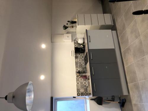 ラ・ロッシュ・シュル・ヨンにあるStudio quartier calmeのキッチン(鏡付)、テレビが備わります。