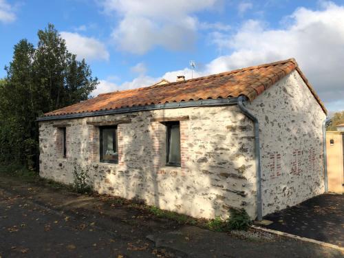 ein altes Steingebäude mit rotem Dach in der Unterkunft Studio quartier calme in La Roche-sur-Yon