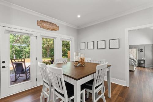 a dining room with a wooden table and white chairs at Relax, Rewind, Repeat - New Country Cottage in High Point