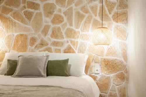 a bedroom with a stone wall with a bed at locanta in Ioannina