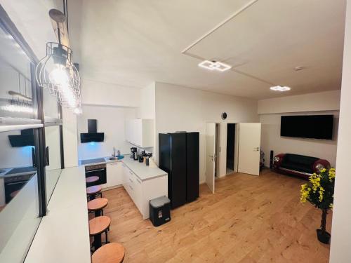 een keuken met witte kasten en een zwarte koelkast bij Big Apartment l 18 Beds l Free Parking l WiFi l in Erwitte