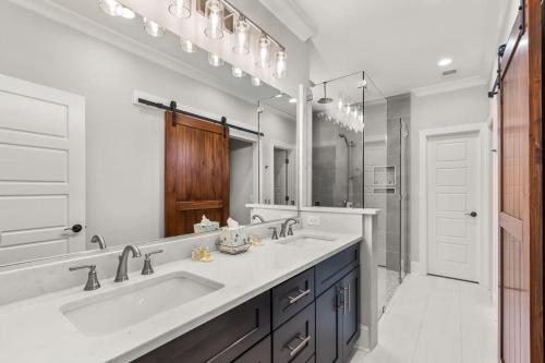 a bathroom with a sink and a large mirror at Relax, Rewind, Repeat - New Country Cottage in High Point