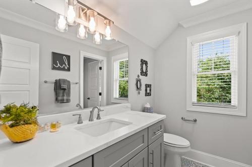 a white bathroom with a sink and a toilet at Relax, Rewind, Repeat - New Country Cottage in High Point