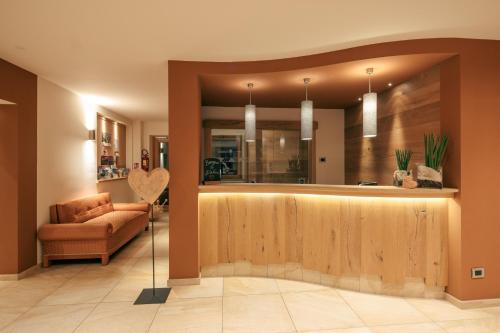 a lobby with a bar with a couch and a chair at Albergo Belvedere in Vigo di Fassa