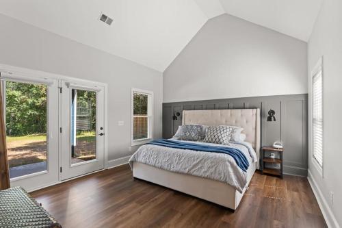 a white bedroom with a large bed and windows at Relax, Rewind, Repeat - New Country Cottage in High Point