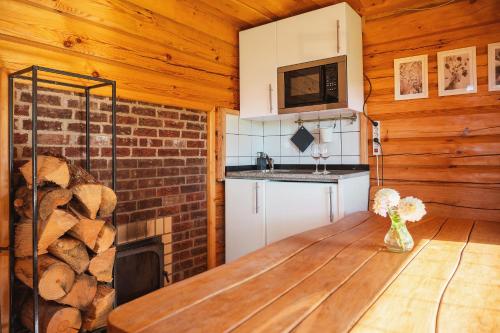 a kitchen with a table and a fireplace in a cabin at House of Sparkles in Elektrėnai