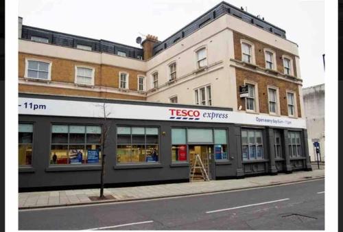 a tesco appliances store on the corner of a street at Spacious One Bedroom Private Flat in Brixton +Wifi in London