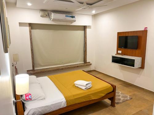 a small room with a bed and a tv at SHARVARI BEACH HOME STAY at Mangalore by Vaishnavi Reveries in Mangalore