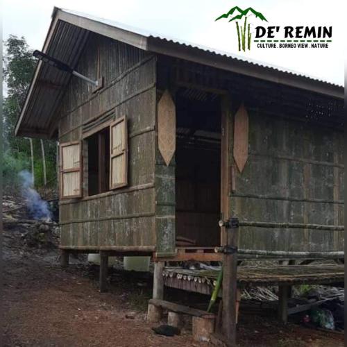 una pequeña casa de madera con un banco delante en De'Remin Sapit, en Kuching