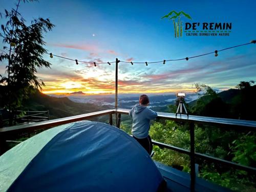 Ein Mann steht neben einem Zelt mit Blick auf den Sonnenuntergang. in der Unterkunft De'Remin Sapit in Kuching