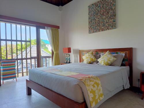 - une chambre avec un grand lit et un balcon dans l'établissement Villa Tounga Sanur, à anur