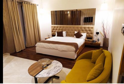 um quarto com uma cama, um sofá e uma mesa em Hotel Riya Imperial By WB Inn em Gondia