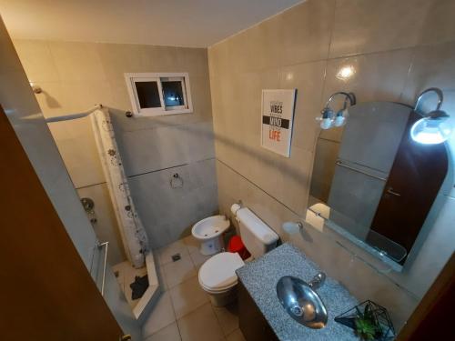 a small bathroom with a toilet and a sink at Portal Sureño in Dina Huapi