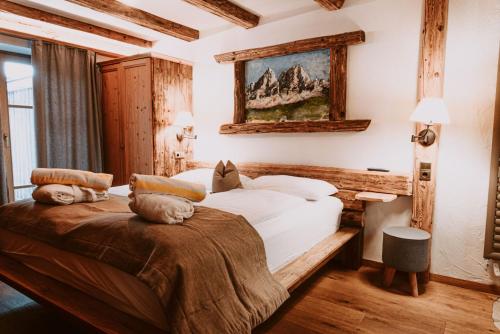 1 dormitorio con 1 cama y una pintura en la pared en Hotel Bergschlössl, en Luson