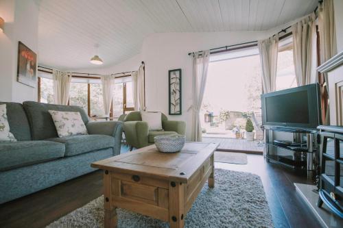 a living room with a couch and a coffee table at Walled Garden Lodges Loch Lomond in Balloch