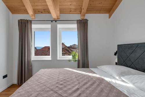 a bedroom with a bed and two windows at Apartment Vise - Old Town Center, Stone Terrace in Omiš