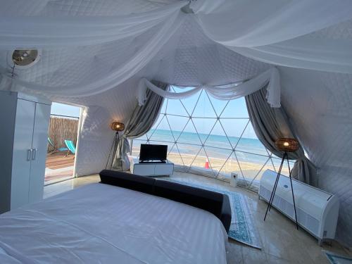 a bedroom with a bed and a view of the ocean at Turquoise Resorts in Ruwais
