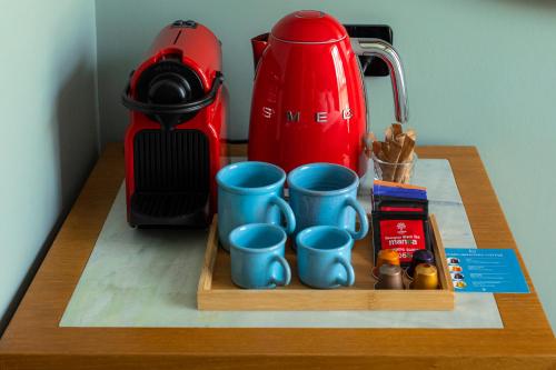 a tray with blue mugs on a table with a tea kettle at Khedi Hotel Tbilisi in Tbilisi City