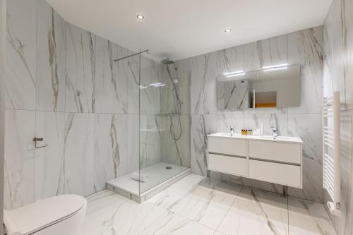 ein weißes Bad mit einem WC und einem Waschbecken in der Unterkunft Sweet Inn - Bastille in Paris