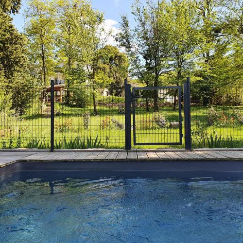 une clôture avec une piscine en face d'une cour dans l'établissement Résidence Espéraza ADULTS ONLY, à Espéraza