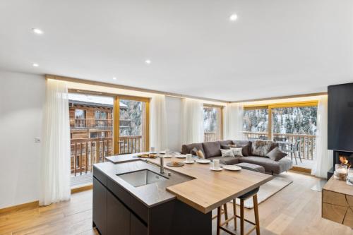 a kitchen and living room with a table and a couch at Chalet Les Rahâs by Mrs Miggins in Grimentz