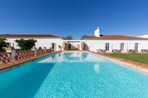 a swimming pool in front of a house at Cenoura-Brava in Évora