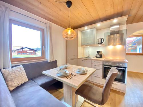 a kitchen and living room with a table and a couch at Best Butler Alp Villa 11 Personen I Blockhütte I Parken I Lagerfeuer I Netflix in Hopferau