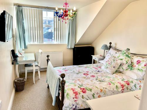 a bedroom with a bed and a desk and a window at The Upper Bakery in Cromer