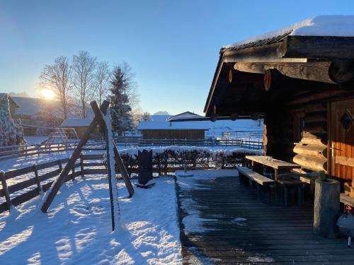 a group of skis sitting in the snow next to a cabin at Best Butler Alp Villa 11 Personen I Blockhütte I Parken I Lagerfeuer I Netflix in Hopferau