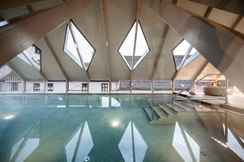an indoor swimming pool with windows in a building at HOTEL & SPA Goldene Rose in Dinkelsbühl
