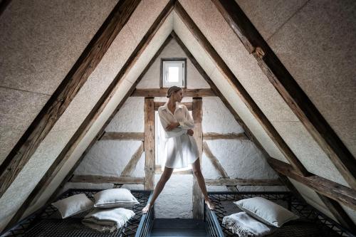 a woman standing in a room with two beds at HOTEL & SPA Goldene Rose in Dinkelsbühl