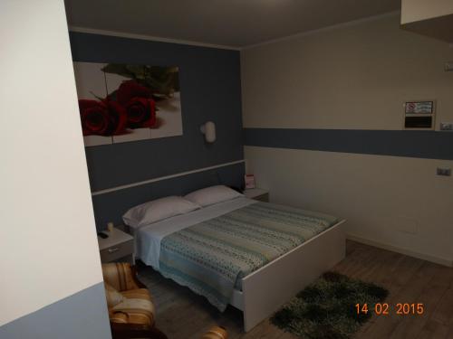 a small bedroom with a bed and a painting on the wall at Hotel Moderno in Grumello del Monte