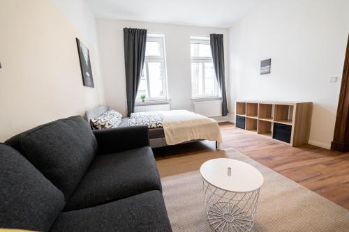 a living room with a couch and a bed at FULL HOUSE 3 Bedroom Apartment Halle NH14 in Halle an der Saale