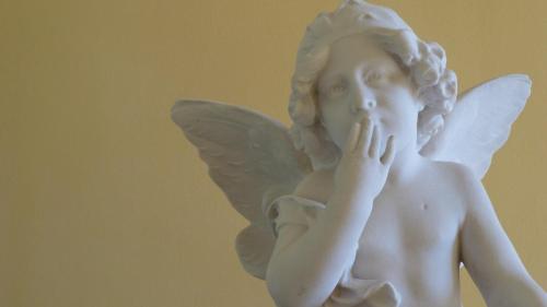 a white statue of a cherub holding his nose at B&B Casa Forster in Cannero Riviera